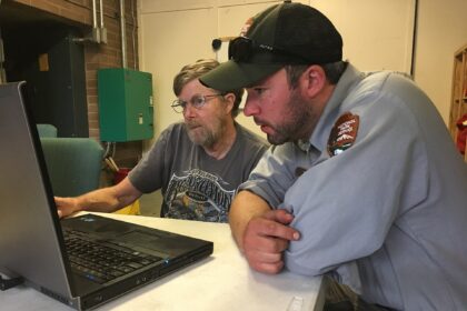 People reviewing data on computer screens in a command centre