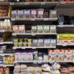 Supermarket shelves stocked with colourful packaged food products in an aisle