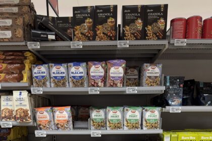 Supermarket shelves stocked with colourful packaged food products in an aisle